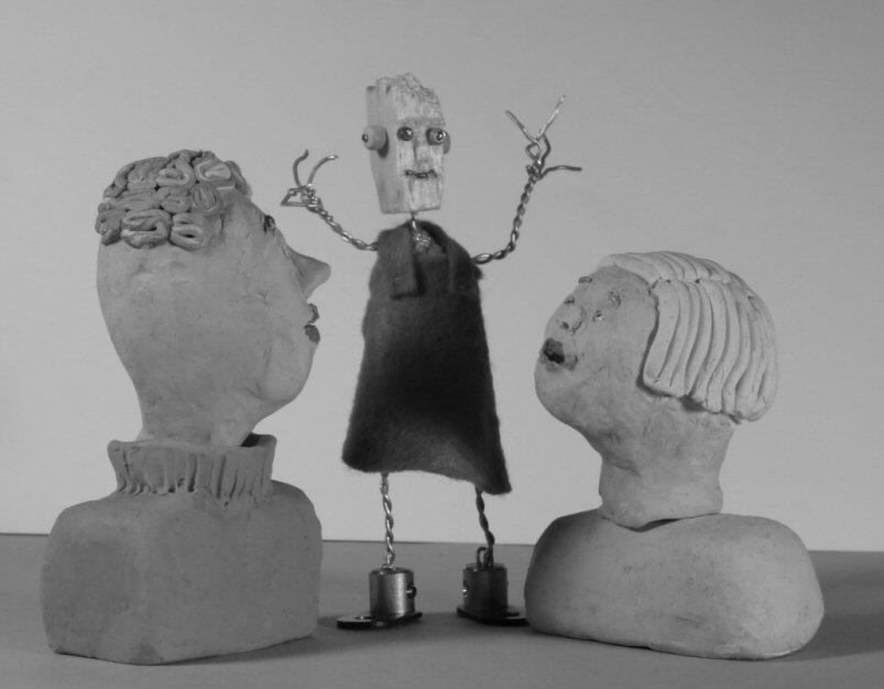 two plasticine heads look at wire model figure