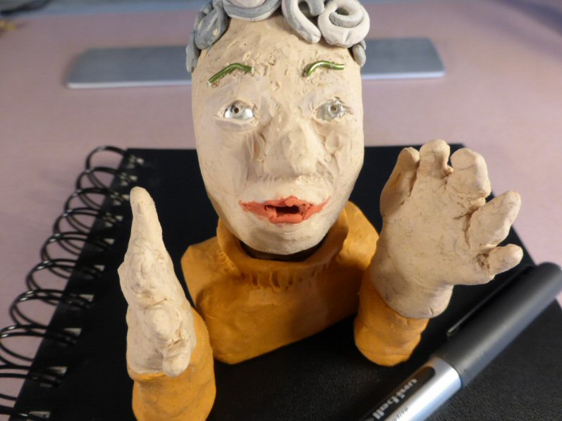 plasticine head on sketchbook looking to camera