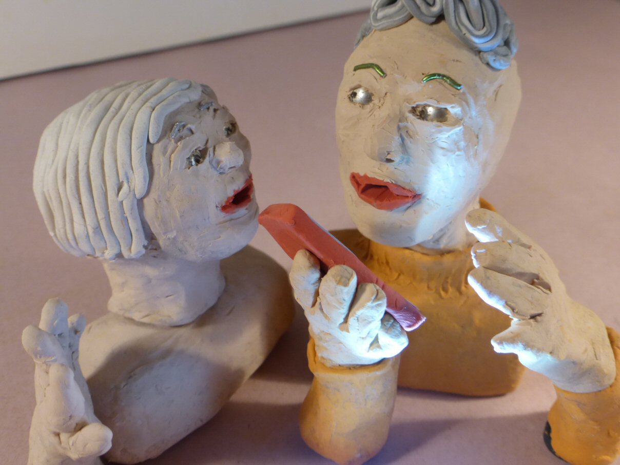 closeup of 2 plasticine heads and smartphone