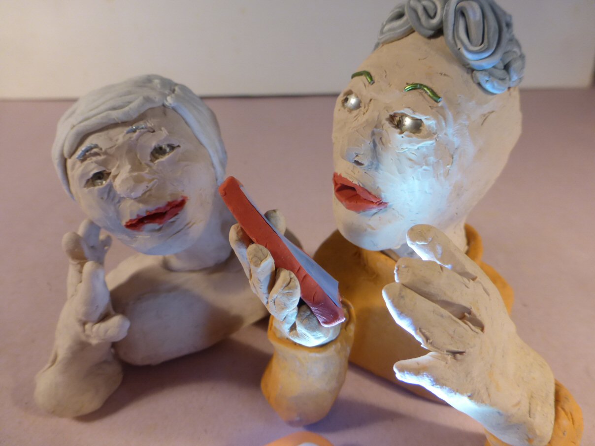 closeup of 2 plasticine heads and smartphone