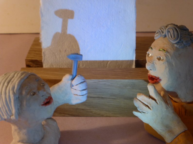 two plasticine heads with hammer and shadow