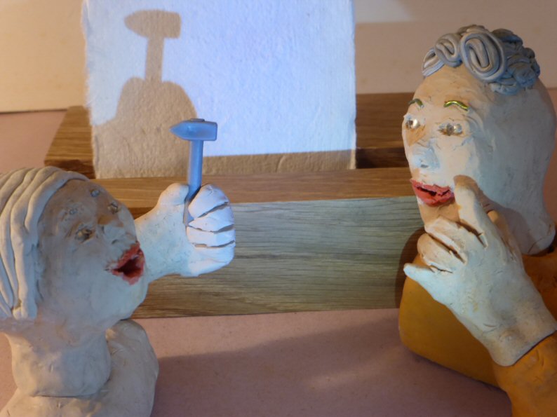 two plasticine heads with hammer and shadow